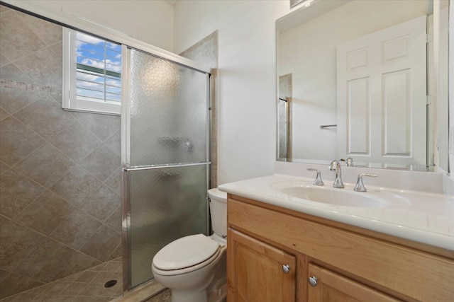 bathroom featuring toilet, an enclosed shower, and vanity