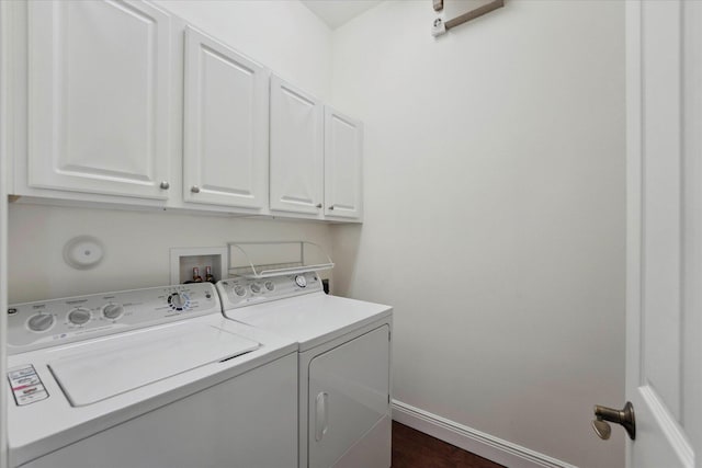 clothes washing area featuring washing machine and dryer and cabinets