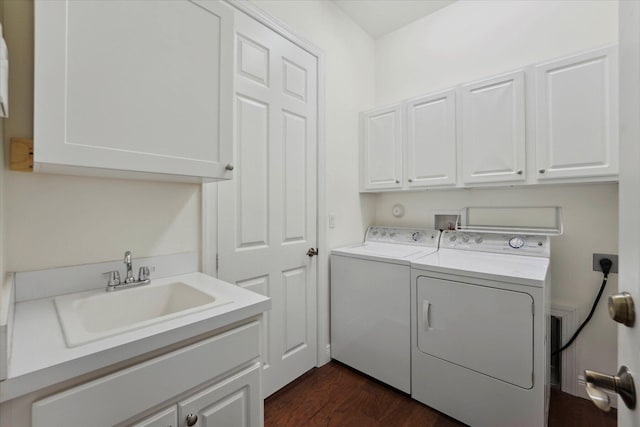 clothes washing area featuring dark hardwood / wood-style flooring, cabinets, sink, and washing machine and clothes dryer