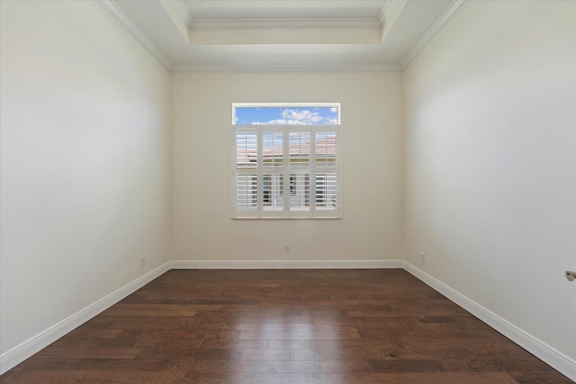 empty room with dark wood-type flooring, ornamental molding, and a raised ceiling