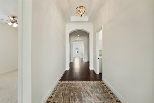 hallway with dark hardwood / wood-style floors, crown molding, and a notable chandelier