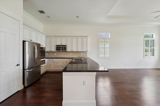 kitchen featuring stainless steel appliances, tasteful backsplash, dark hardwood / wood-style floors, crown molding, and white cabinetry