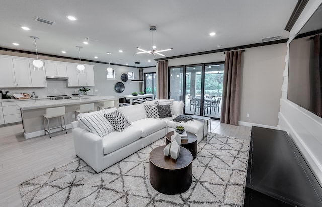 living area featuring recessed lighting, visible vents, light wood finished floors, and ornamental molding