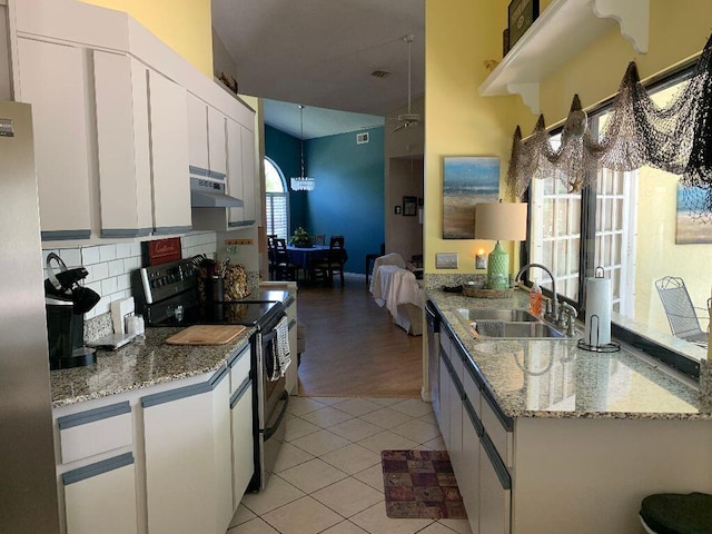 kitchen featuring stainless steel appliances, sink, light stone countertops, light tile patterned floors, and white cabinets