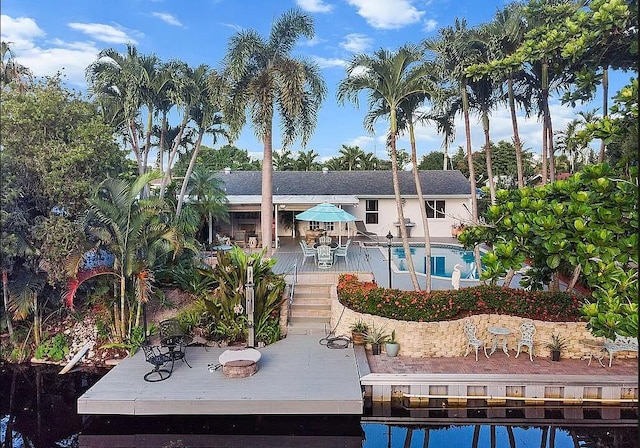 rear view of house featuring a swimming pool side deck