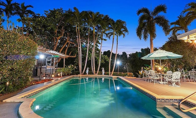 pool at dusk with a patio