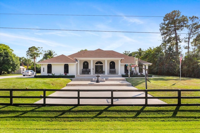 mediterranean / spanish home featuring a front lawn and covered porch