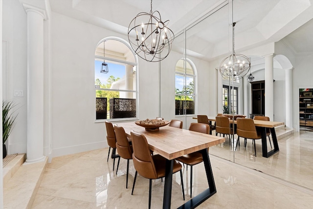 dining space featuring a notable chandelier, ornate columns, and a tray ceiling