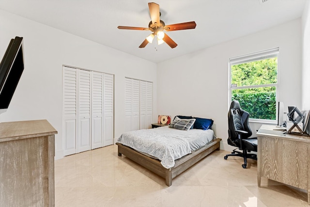 bedroom featuring ceiling fan and two closets