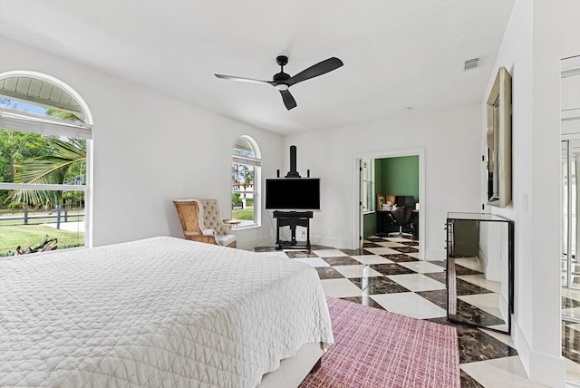 bedroom with ceiling fan, ensuite bathroom, and multiple windows