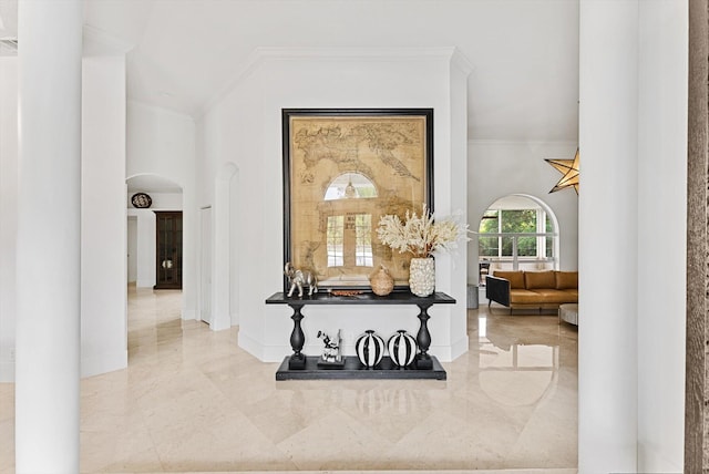 hallway with crown molding and a high ceiling