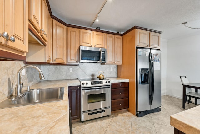 kitchen featuring appliances with stainless steel finishes, sink, backsplash, and light tile patterned flooring