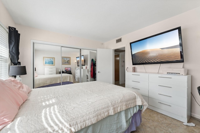 bedroom featuring light tile patterned floors and a closet