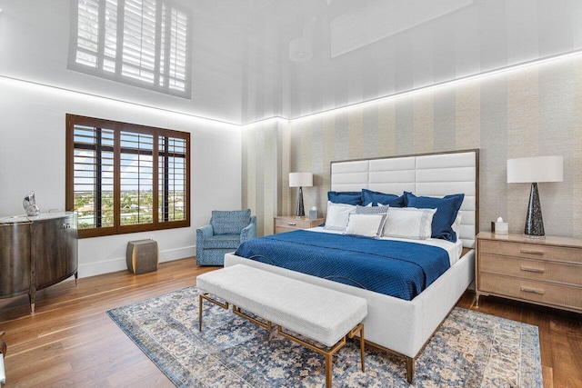 bedroom featuring hardwood / wood-style flooring and a high ceiling