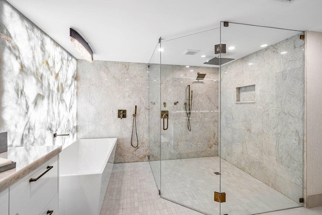 bathroom with tile patterned flooring, tile walls, and independent shower and bath