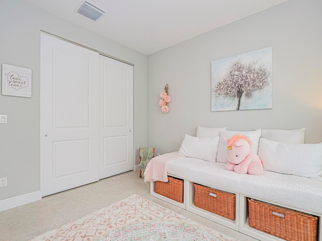 tiled bedroom with a closet