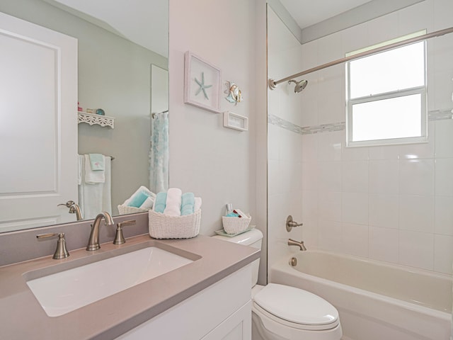 full bathroom with vanity, tiled shower / bath combo, and toilet