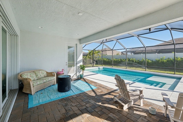 view of pool with a patio area, a fenced in pool, outdoor lounge area, and glass enclosure