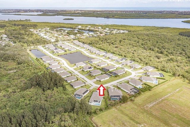 bird's eye view featuring a wooded view, a residential view, and a water view