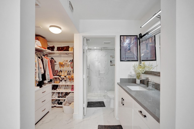 bathroom featuring vanity, a shower with shower door, and toilet