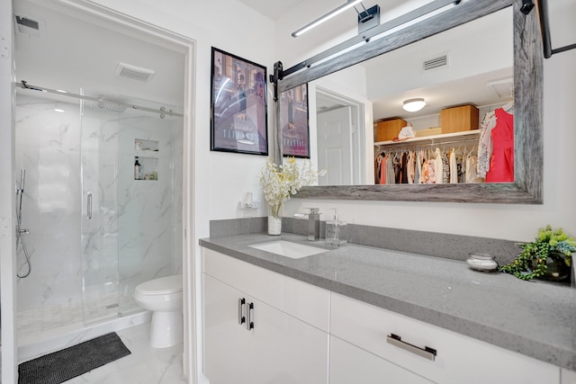 bathroom with vanity, a shower with shower door, and toilet