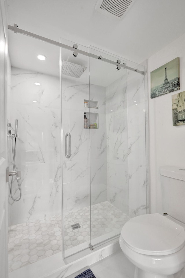 bathroom featuring toilet and an enclosed shower