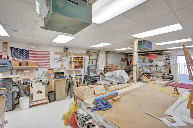 basement with a paneled ceiling and a workshop area