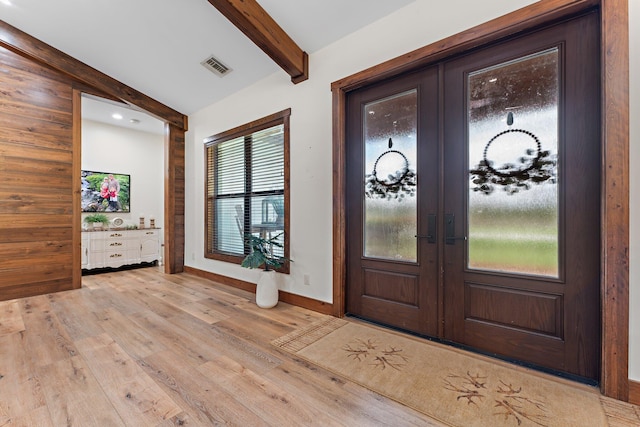 entryway featuring beamed ceiling, light hardwood / wood-style floors, and french doors