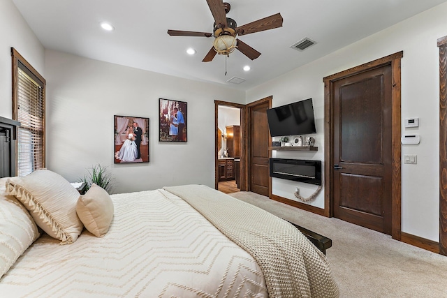 carpeted bedroom featuring ceiling fan and ensuite bathroom