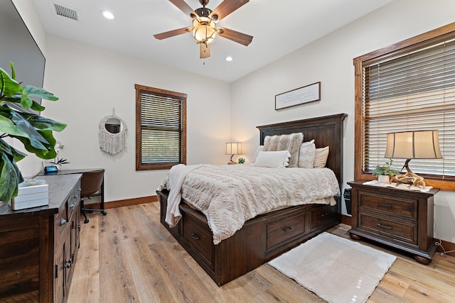 bedroom featuring multiple windows, light hardwood / wood-style floors, and ceiling fan