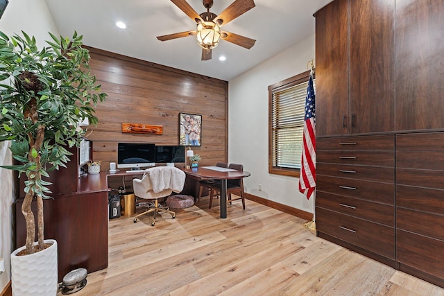 home office with ceiling fan, light hardwood / wood-style floors, and wooden walls