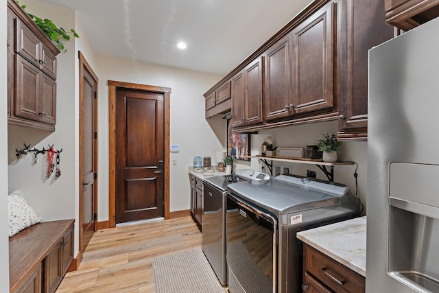 washroom featuring cabinets, separate washer and dryer, and light wood-type flooring