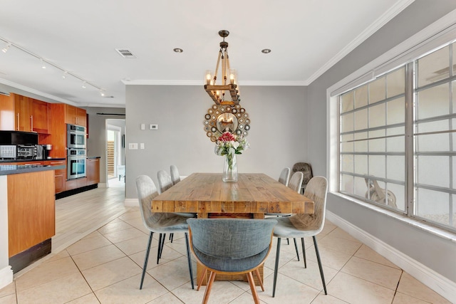 dining area with a chandelier, light tile patterned floors, track lighting, and crown molding