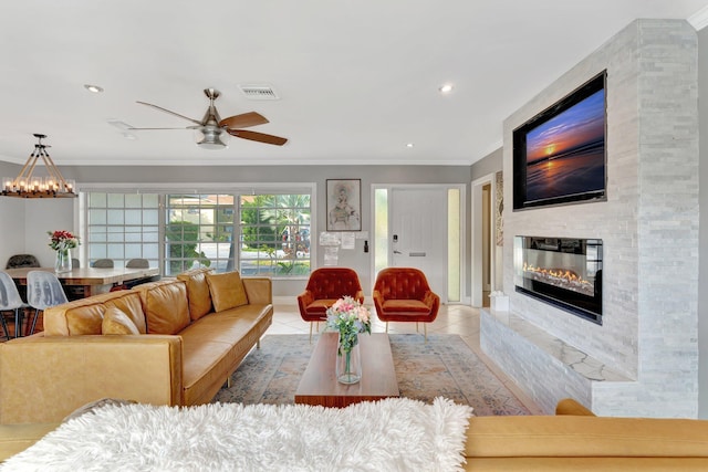 tiled living room with a fireplace, ceiling fan, and ornamental molding