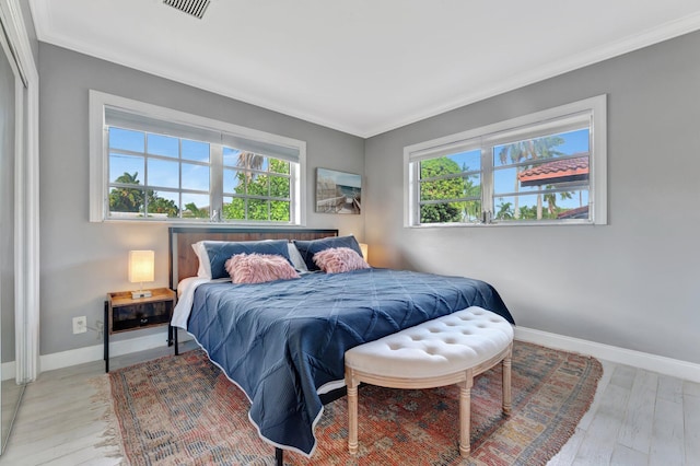 bedroom with light hardwood / wood-style floors and ornamental molding