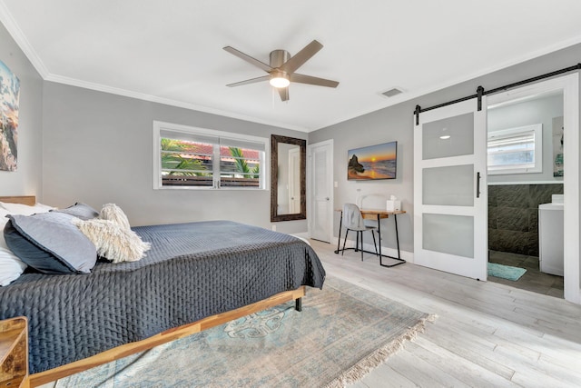 bedroom with light wood-type flooring, ensuite bathroom, ornamental molding, ceiling fan, and a barn door