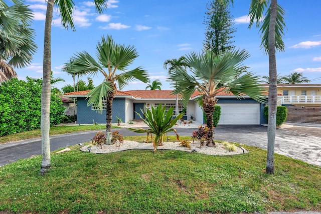 single story home featuring a garage and a front lawn