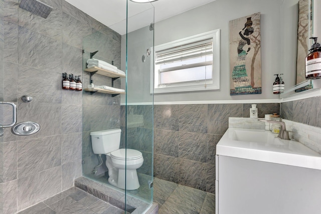 bathroom featuring an enclosed shower, vanity, toilet, and tile walls