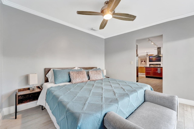 bedroom featuring ceiling fan, light hardwood / wood-style flooring, and ornamental molding