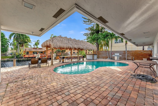 view of swimming pool featuring a gazebo, a grill, a patio area, and a water view