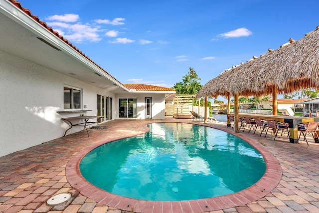 view of swimming pool featuring a gazebo, a patio area, and exterior bar