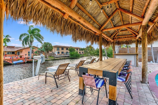 view of patio / terrace with a gazebo, a water view, and a boat dock