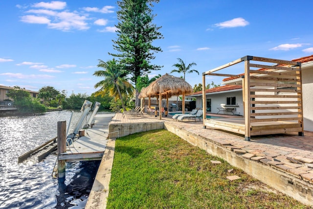 view of dock with a water view and a lawn