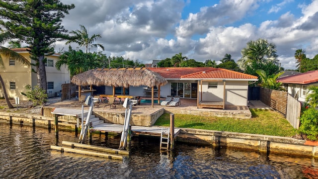 back of house featuring a patio, a water view, and a pool