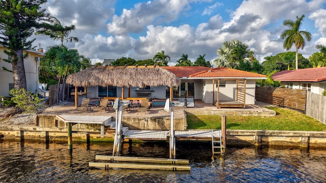 back of house with a water view and a patio