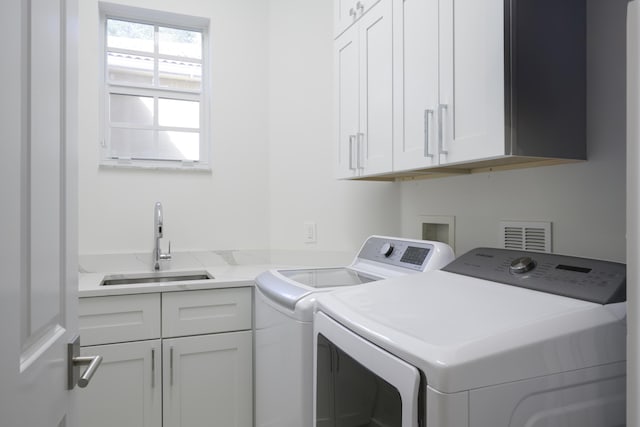 laundry area with washer and dryer, cabinets, and sink