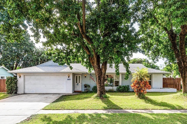 single story home featuring a garage and a front lawn