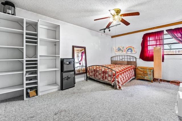 carpeted bedroom with ceiling fan, rail lighting, and a textured ceiling