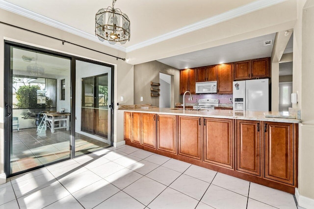 kitchen with white appliances, pendant lighting, a chandelier, crown molding, and sink