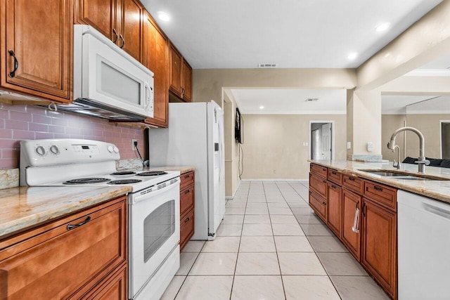 kitchen featuring tasteful backsplash, sink, white appliances, light tile patterned floors, and light stone counters